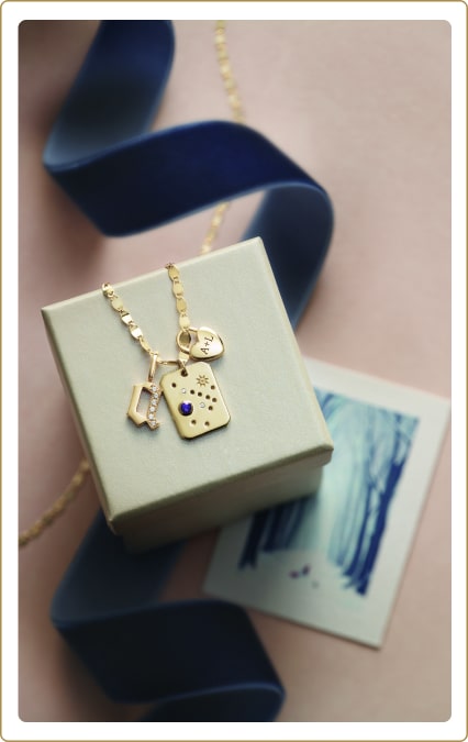 Photo of gold necklace on box with ribbon