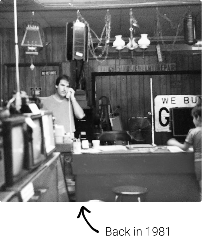 Photo of man behind counter on phone back in 1981